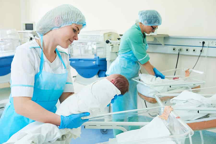 young female neonatal nurse holding a newborn